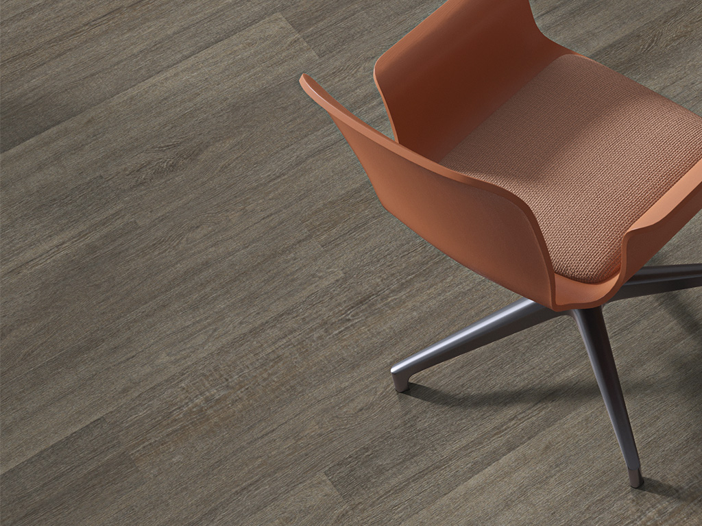 Dusky Gray luxury vinyl plank installed in a modern commercial setting, featuring soft gray-brown wood tones, subtle grain texture, and a random plank layout.