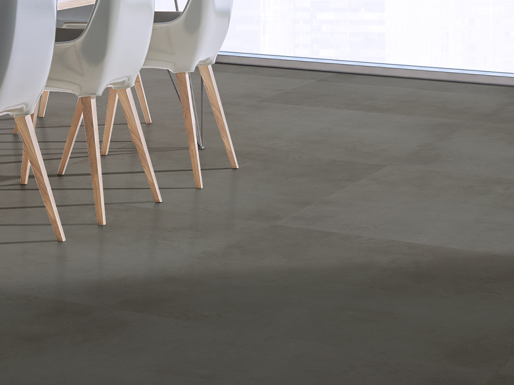 Select Gunmetal luxury vinyl tile in a large-format 36" x 36" installation, featuring a smooth concrete-inspired surface in deep gray tones.