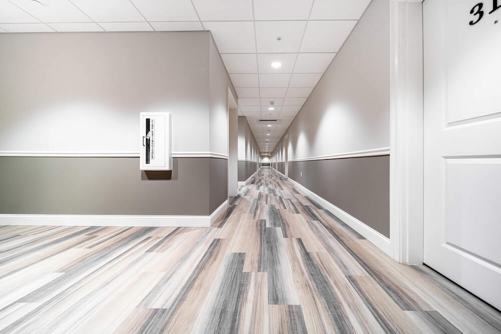 A serene hallway with sound-absorbing wood flooring and clean white walls, enhancing both comfort and aesthetics.