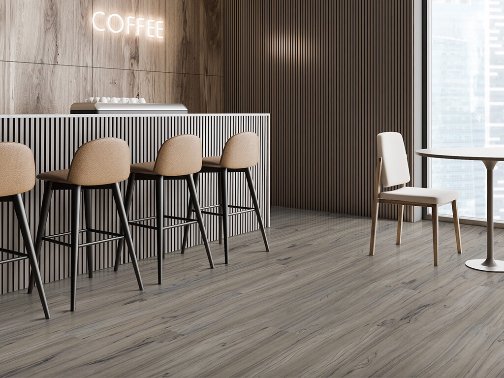 Exowood Gray LVT flooring in a cafe with a wooden counter, beige bar stools, neon COFFEE sign, and modern dining table set against vertical wood paneling.