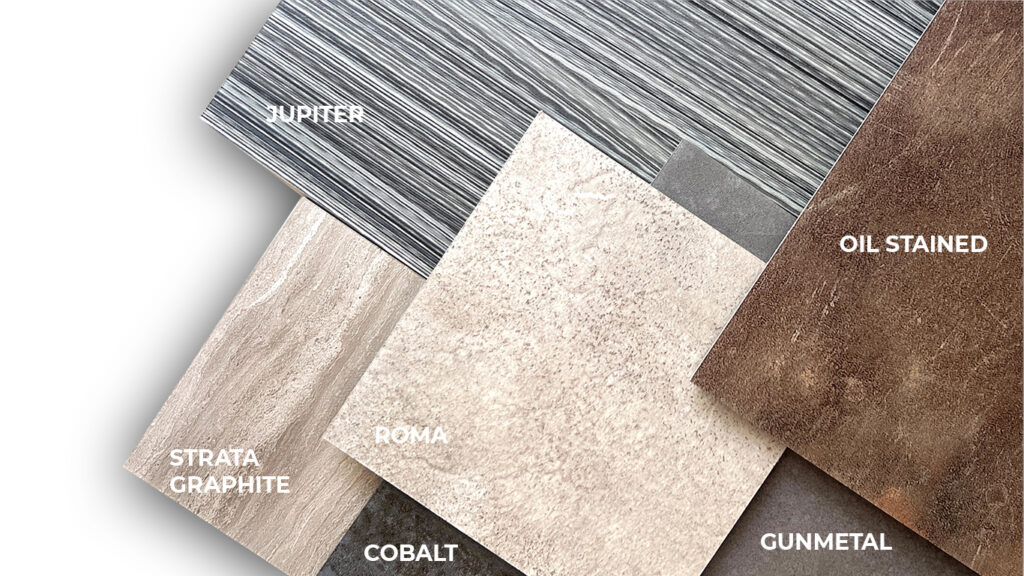 Luxury vinyl tile and plank samples from the TAJ Select Non-Woods collection, featuring Jupiter, Strata Graphite, Roma, Cobalt, Gunmetal, and Oil Stained. The assortment showcases woven linear, travertine, metal patina, concrete, and stained concrete visuals for commercial flooring applications.